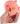 Hand holding a pink pig-shaped stress reliever toy against a white background