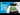 Aqua One Lifestyle Classic Set-Up aquarium with a black lid, black base, clear glass tank, white gravel, green plants, and gray rocks, shown against a blue and white graphic background with the Aqua One logo.